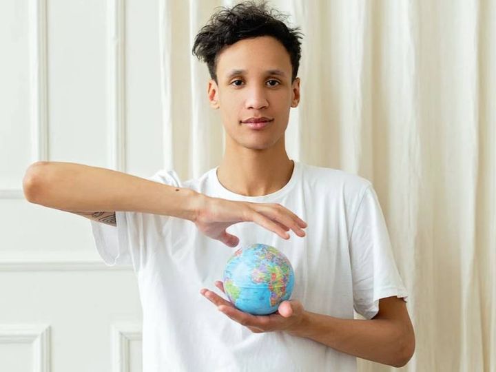 jeune qui tient un globe dans les mains